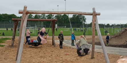 Børn leger udenfor på gyngerne