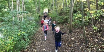 Børn der løber i skoven